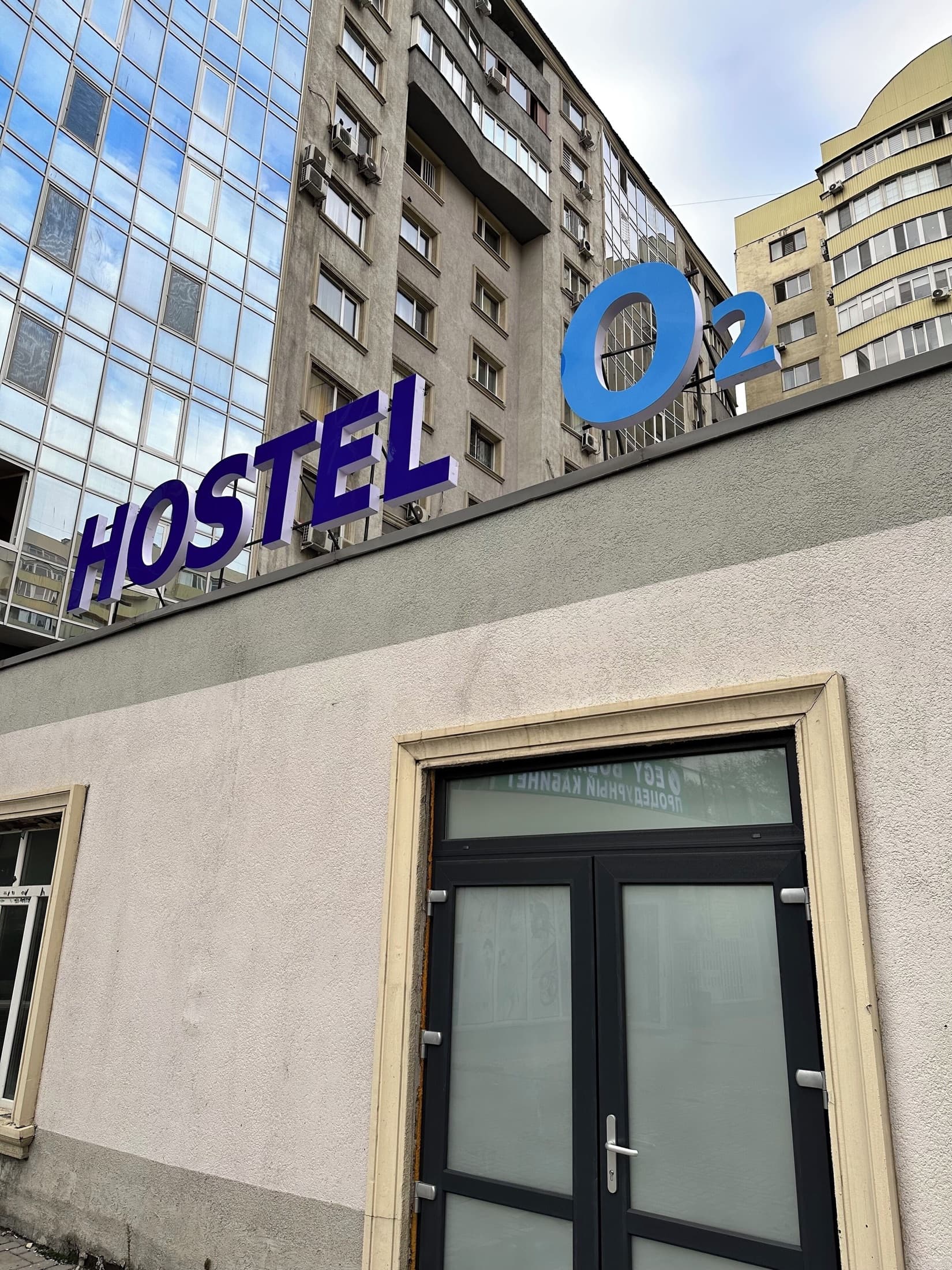 Вход в Hostel O2 с фирменной вывеской